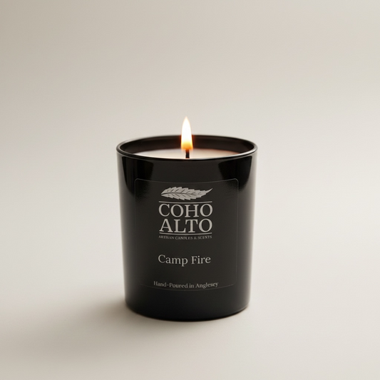 Candle in a black container labeled 'Coho Alto Camp Fire' on a light background