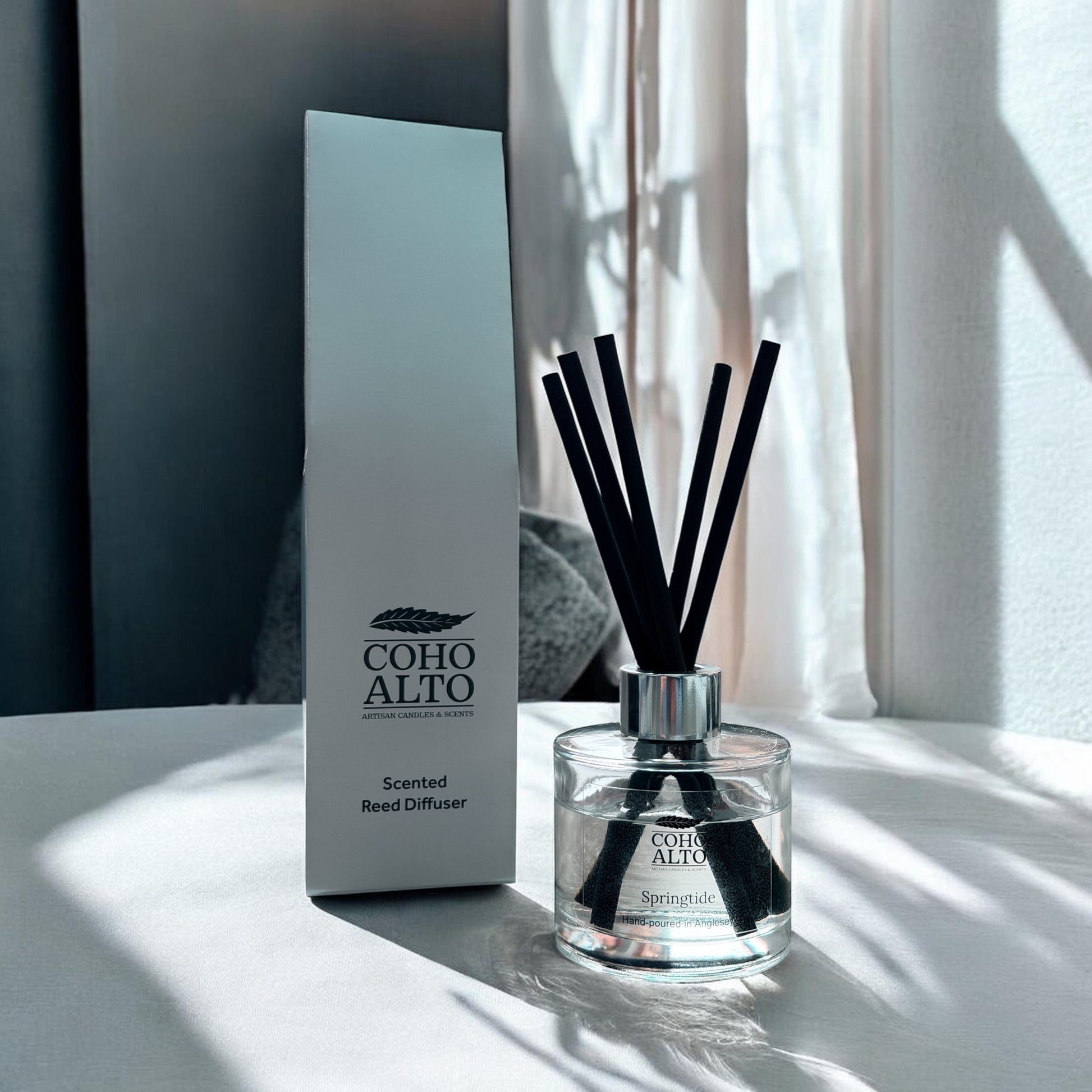 Coho Alto luxury reed diffuser with packaging on a light surface with soft shadows